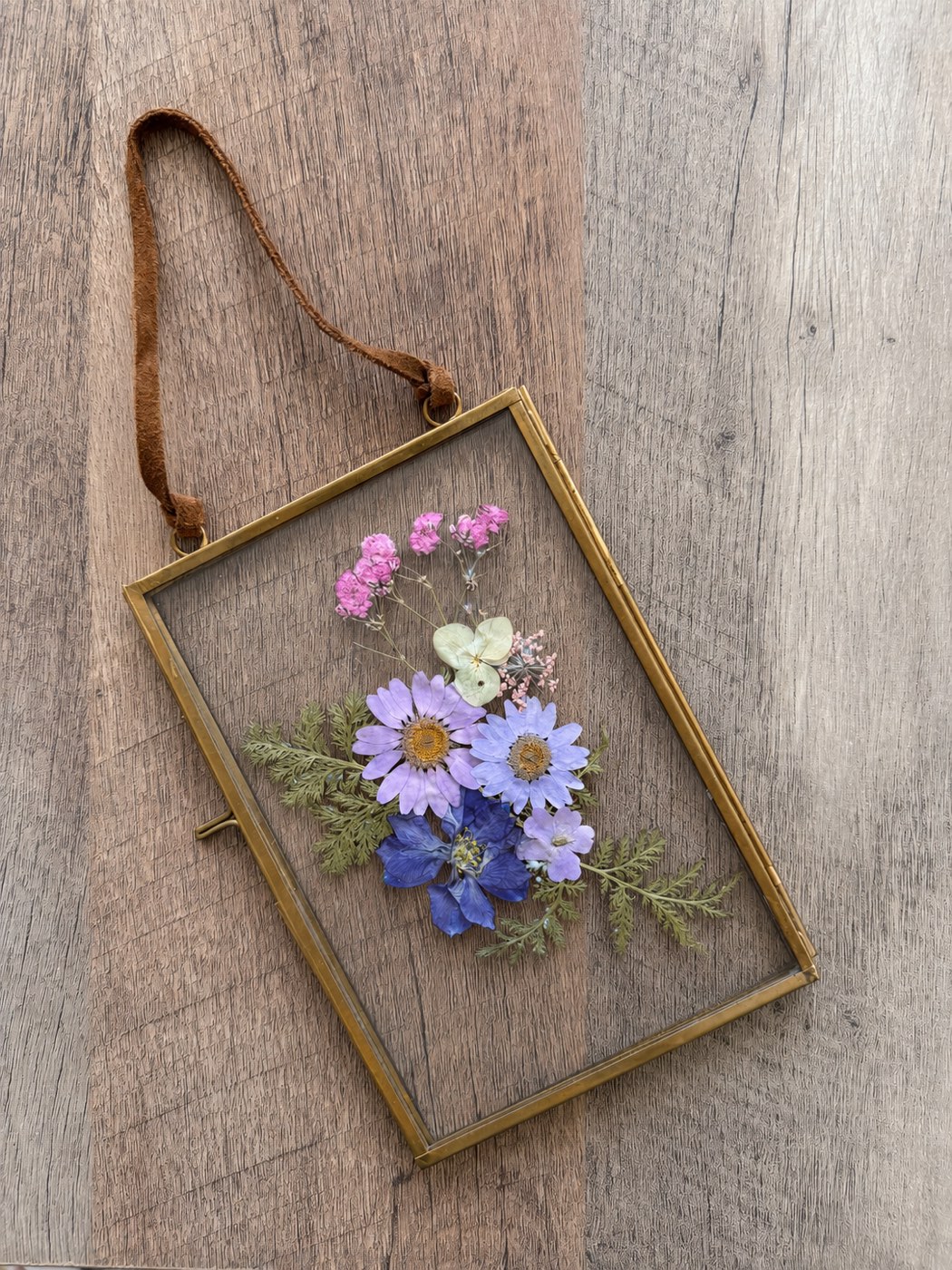 Finished pressed flower keepsake in a hanging brass frame