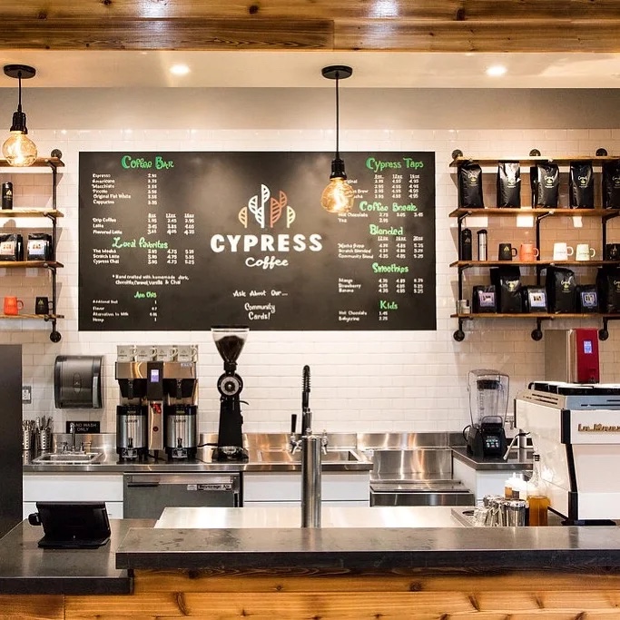 Inside Cypress Coffee in Redmond — the coffee bar, hand-lettered menu board, and warm cedar ceiling