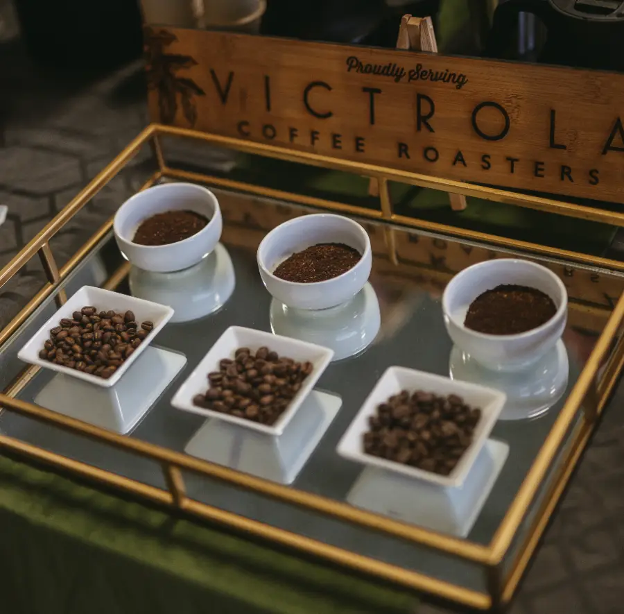Bowls of whole beans and ground coffee on a mirrored tray at the Victrola Coffee Roasters table